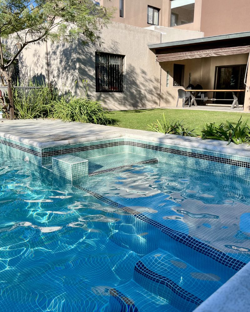 Pileta con escalón sumergido revestida con venecitas Neobind en tono verde agua